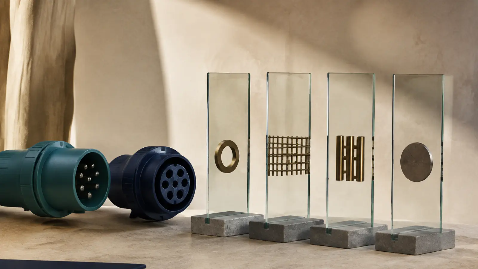 Due connettori industriali aperti accanto a quattro pannelli di vetro in sequenza, ciascuno con un oggetto metallico diverso, a rappresentare gate decisionali successivi.